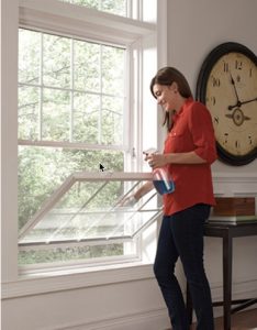 woman cleaning a double hung window
